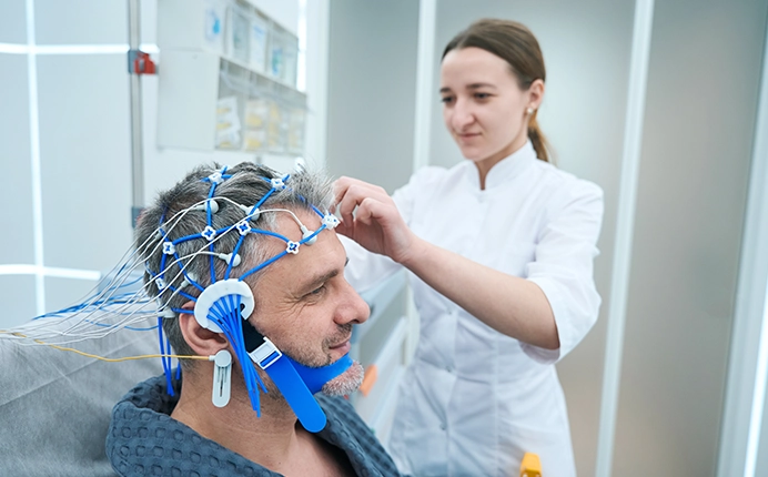 Nurse prepping patient for EEG monitoring